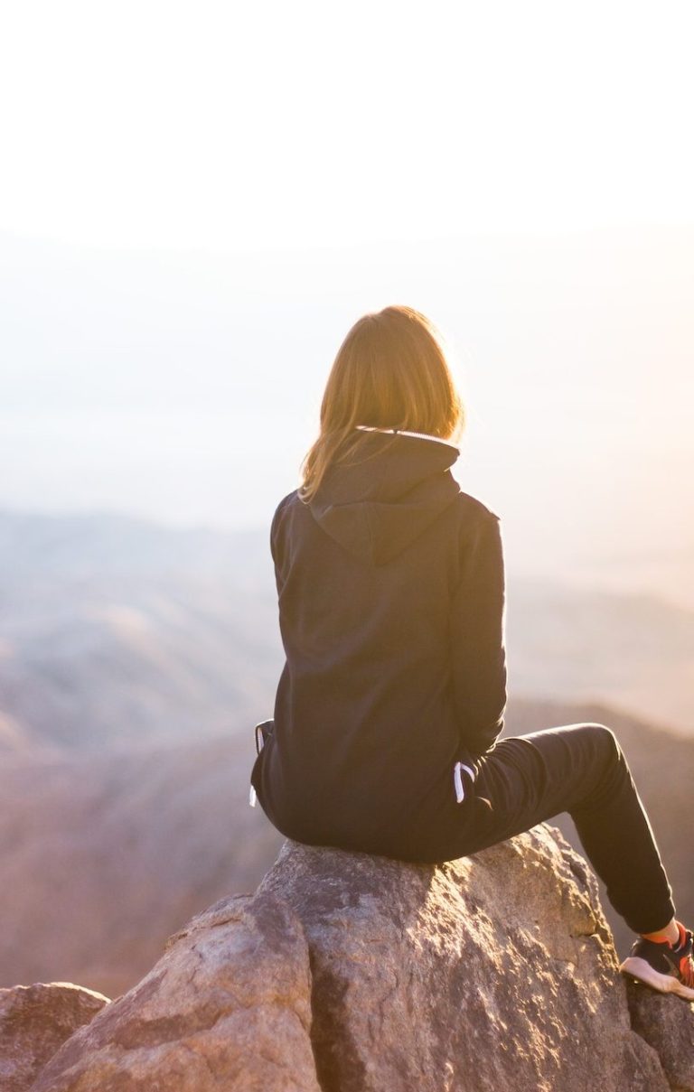 selbstbewusste glückliche Frau auf einem Bergfelsen mit Aussicht 
